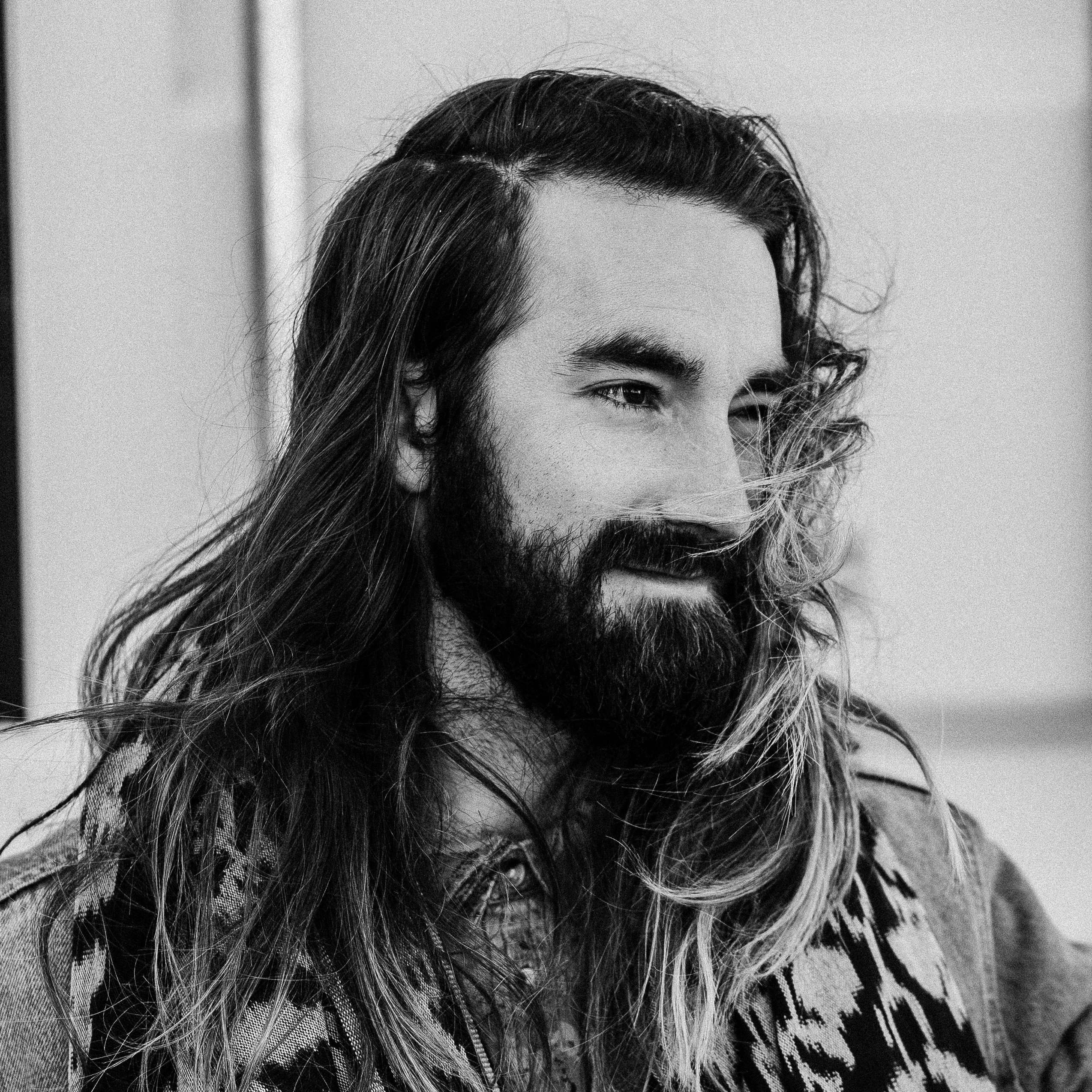 a man with a long haircut and beard